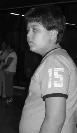 Vitor Santos na infância, de perfil, usando camisa com o número 15.