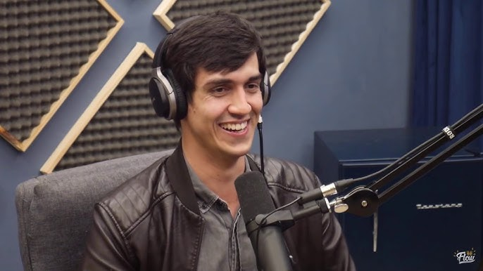 Vitor Santos em entrevista de podcast, usando headphones.