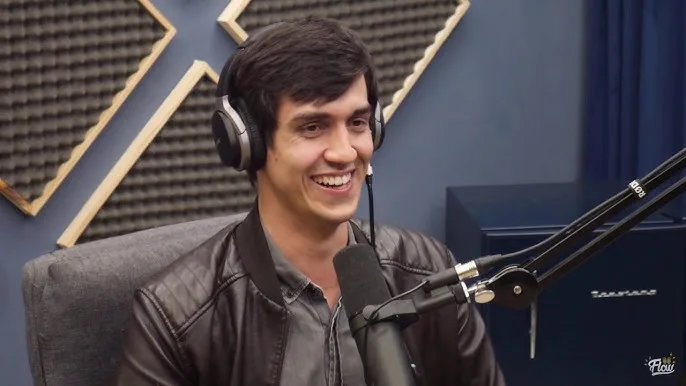 Vitor Santos em entrevista de podcast, usando headphones.